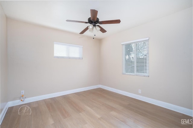 spare room featuring a ceiling fan, baseboards, and light wood-type flooring