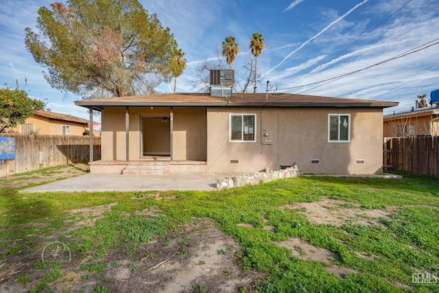 rear view of property with a patio area, fence, and stucco siding