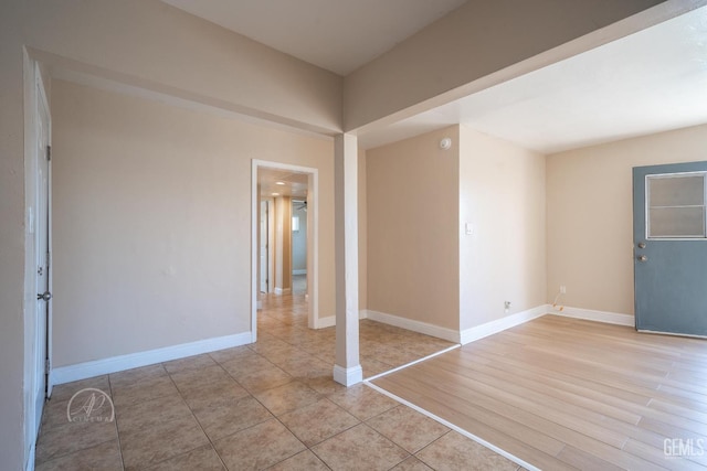 spare room featuring light wood-style flooring and baseboards