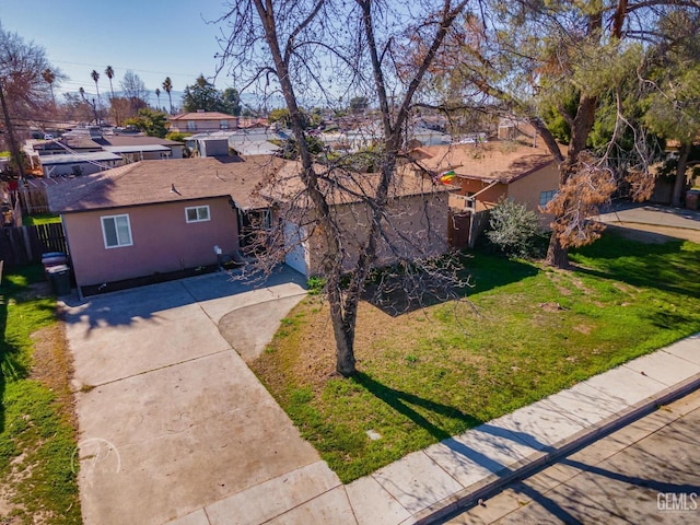 exterior space featuring stucco siding, a patio, a front lawn, and fence