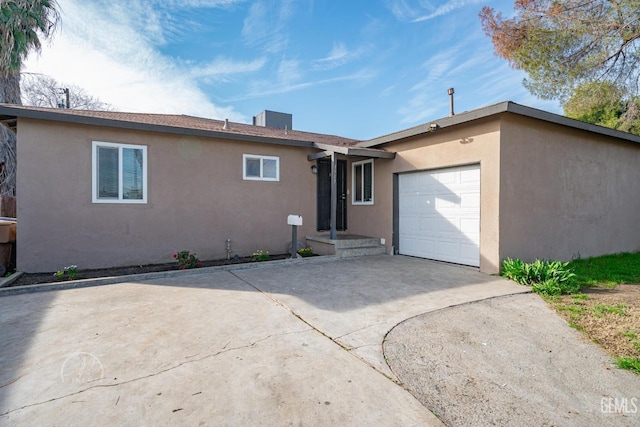 single story home featuring stucco siding, driveway, and an attached garage