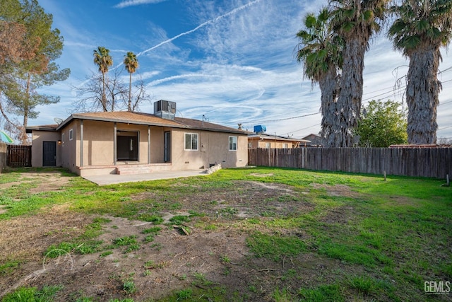 rear view of house featuring a patio area, cooling unit, a fenced backyard, and stucco siding