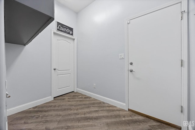foyer featuring baseboards and wood finished floors