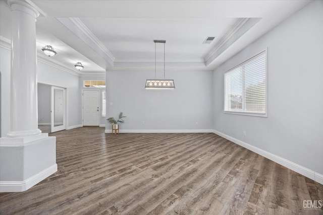interior space featuring visible vents, ornate columns, wood finished floors, and a raised ceiling