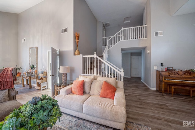 living room featuring hardwood / wood-style floors and a towering ceiling