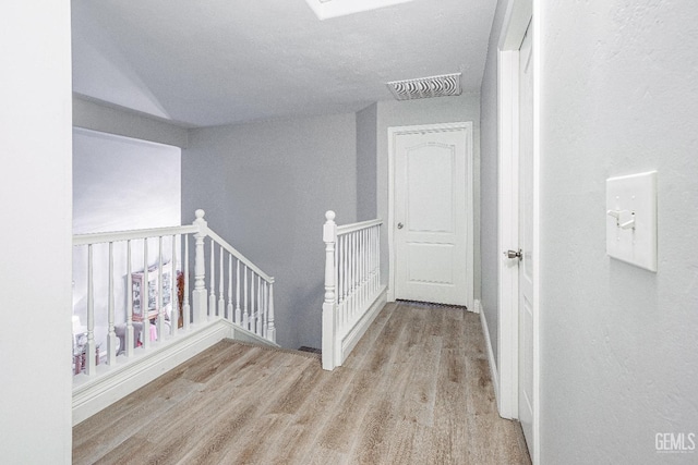 corridor with light hardwood / wood-style floors