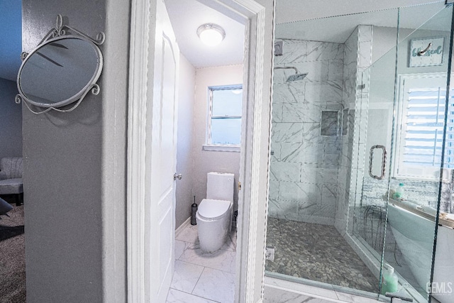 bathroom featuring toilet and a shower with door