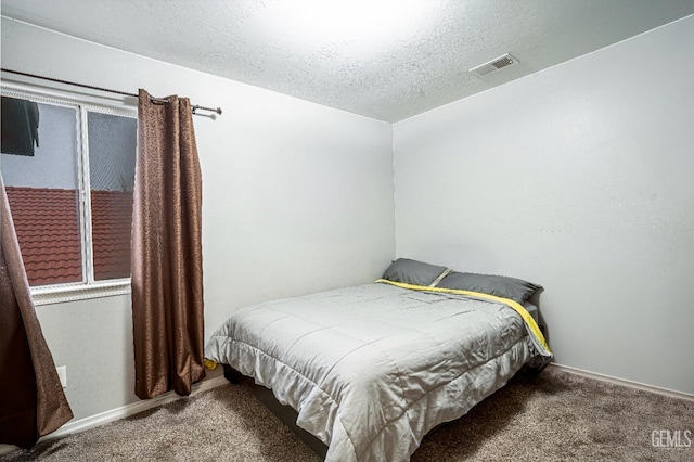 bedroom with carpet and a textured ceiling