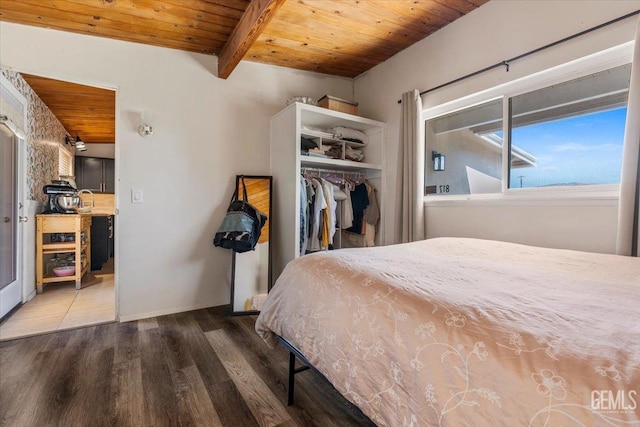 unfurnished bedroom with sink, wood ceiling, beam ceiling, wood-type flooring, and a closet