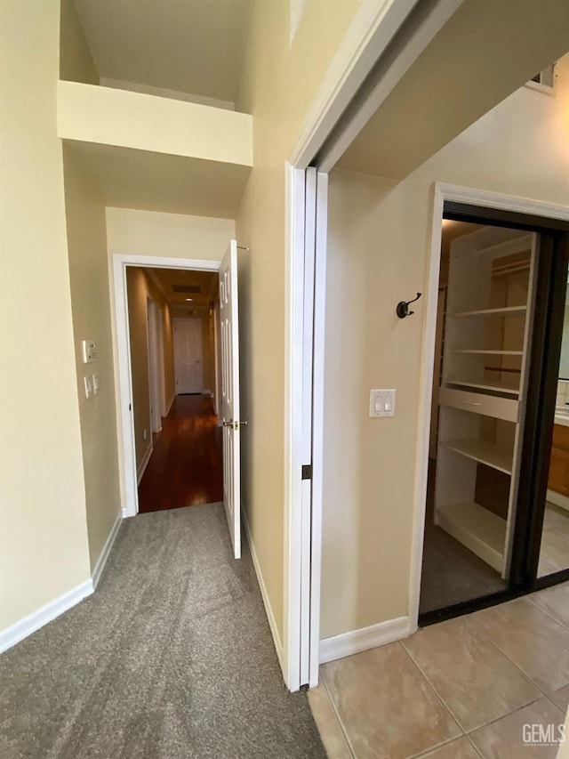 hall featuring carpet and baseboards