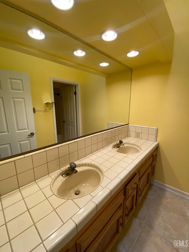 full bathroom featuring double vanity, decorative backsplash, a sink, and recessed lighting