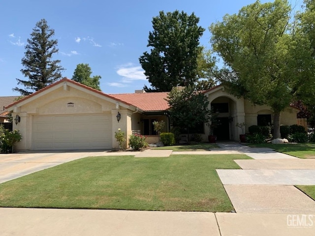 view of front of home with stucco siding, a front yard, a garage, driveway, and a tiled roof