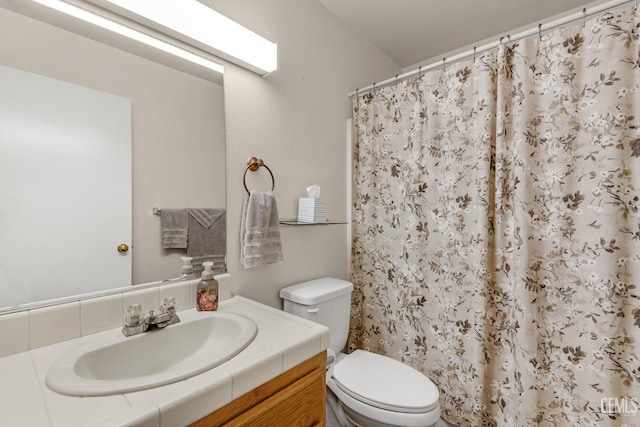 bathroom with a shower with shower curtain, vanity, and toilet