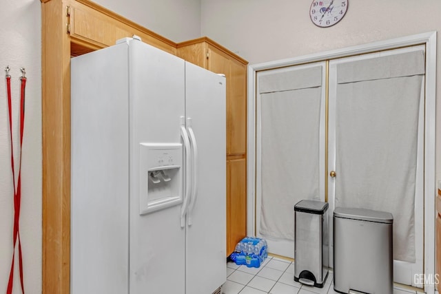 kitchen featuring white fridge with ice dispenser, light tile patterned flooring, and light brown cabinets