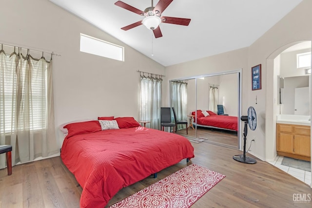 bedroom featuring ceiling fan, light wood-type flooring, ensuite bathroom, and a closet