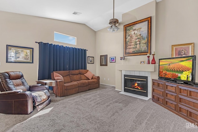 carpeted living room with a tile fireplace and lofted ceiling