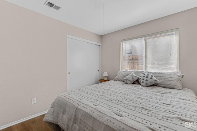 bedroom featuring wood-type flooring and a closet