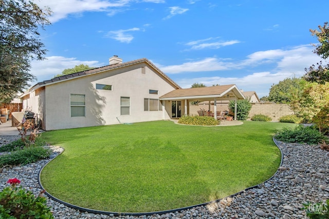 rear view of property with a yard