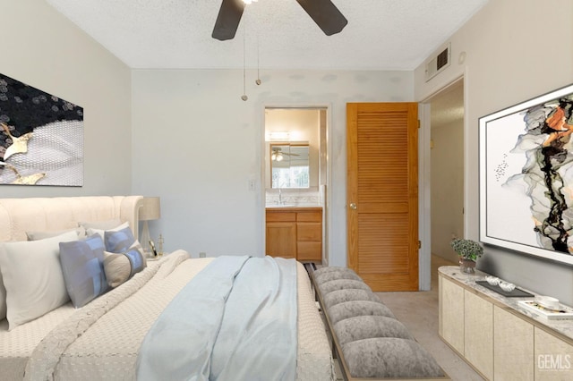 726 D St, Taft, CA 93268 - bedroom featuring a sink, a textured ceiling, ensuite bathroom, ceiling fan, and light colored carpet