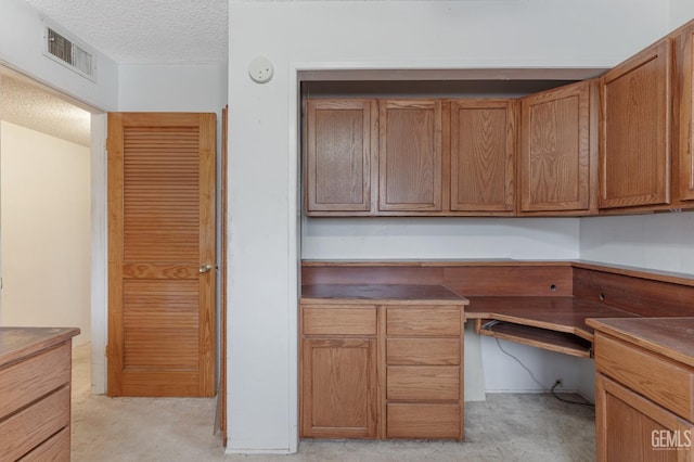 726 D St, Taft, CA 93268 - unfurnished office featuring visible vents, built in study area, a textured ceiling, and light colored carpet