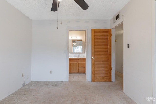 726 D St, Taft, CA 93268 - unfurnished bedroom with ensuite bathroom, a textured ceiling, a sink, light carpet, and visible vents