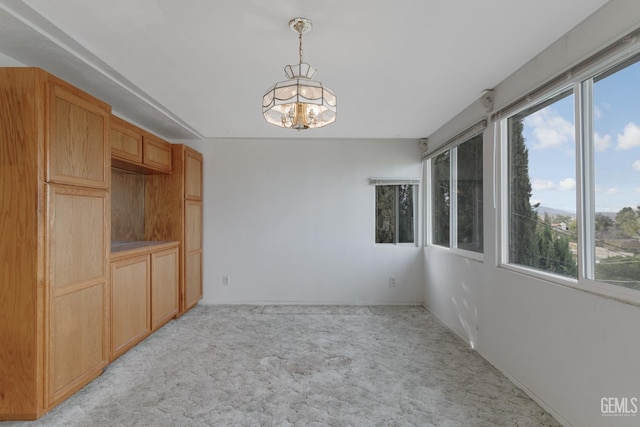 726 D St, Taft, CA 93268 - unfurnished dining area featuring a chandelier, plenty of natural light, and light colored carpet