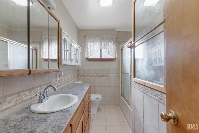 726 D St, Taft, CA 93268 - bathroom featuring tile patterned floors, toilet, tile walls, vanity, and enclosed tub / shower combo