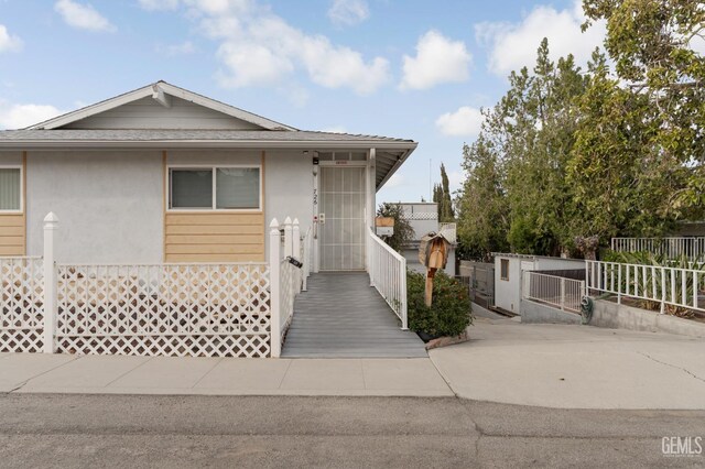726 D St, Taft, CA 93268 - view of front of house featuring fence, a gate, roof with shingles, and stucco siding