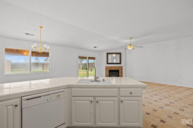 kitchen featuring white cabinets, a sink, visible vents, ceiling fan with notable chandelier, and white dishwasher