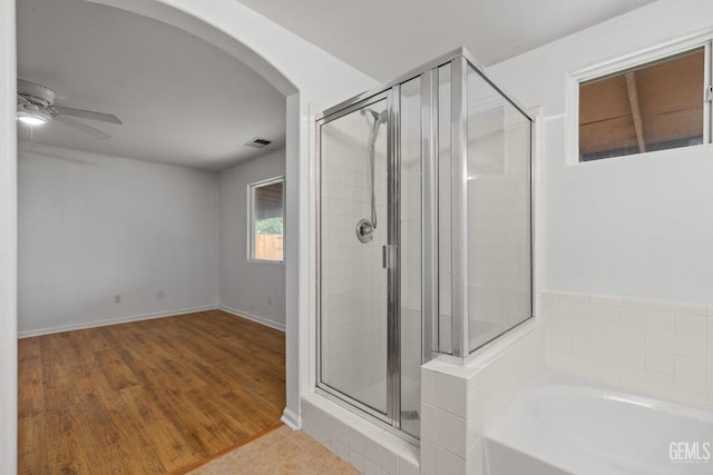 full bath with a shower stall, wood finished floors, visible vents, a ceiling fan, and a garden tub