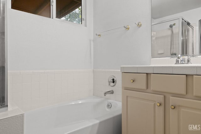 bathroom featuring a shower stall, a garden tub, and vanity