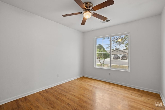unfurnished room featuring baseboards, a ceiling fan, visible vents, and light wood-style floors