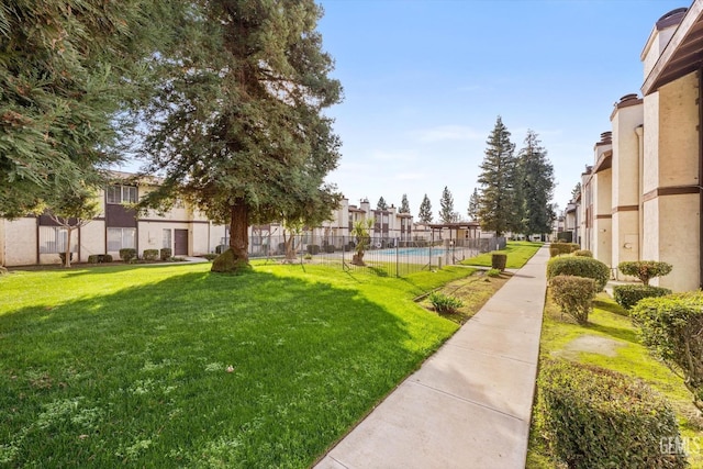 view of property's community featuring a pool and a lawn