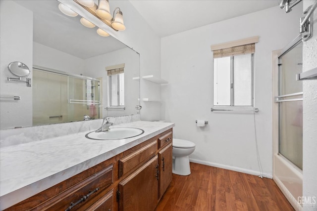 full bathroom with vanity, hardwood / wood-style flooring, a wealth of natural light, and toilet