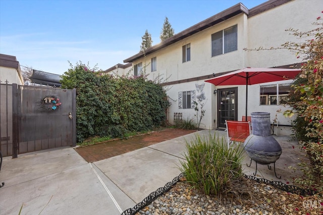 rear view of house featuring a patio area and a fire pit