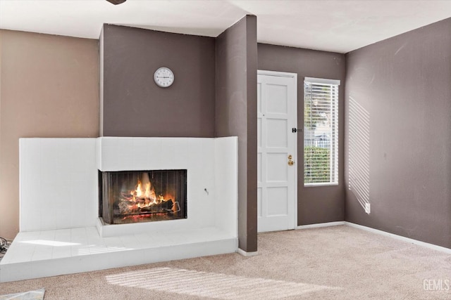 unfurnished living room featuring a multi sided fireplace and carpet