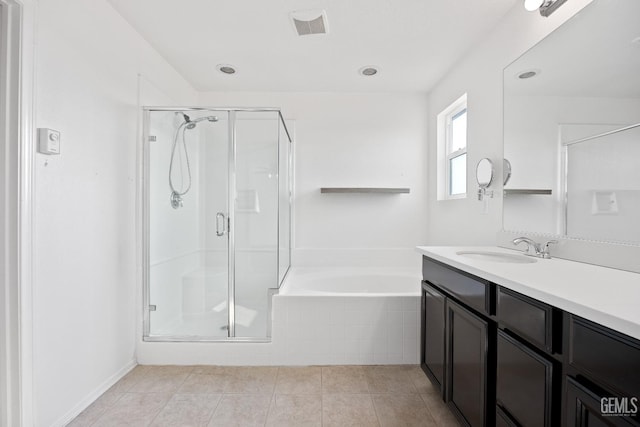 bathroom with tile patterned flooring, vanity, and plus walk in shower