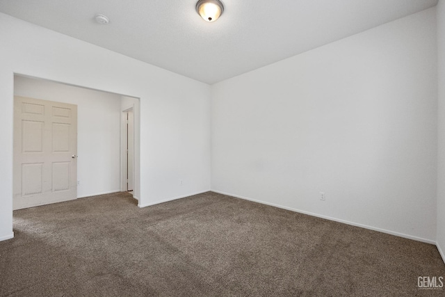 unfurnished room featuring dark carpet