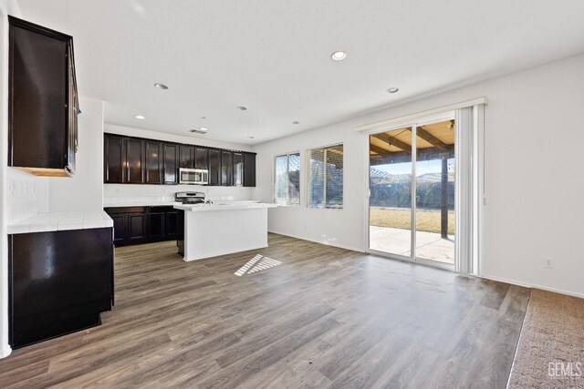 unfurnished living room featuring dark hardwood / wood-style flooring and brick wall