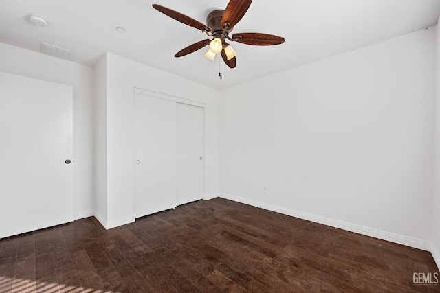 spare room featuring ceiling fan and dark wood-type flooring