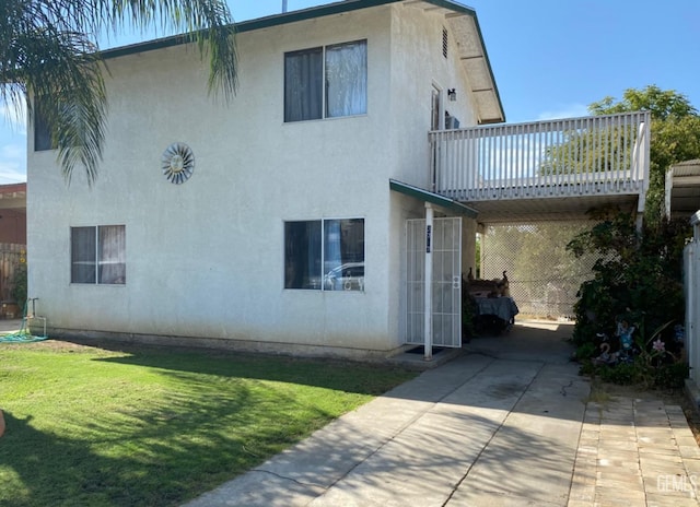 rear view of house featuring a deck and a lawn