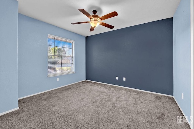 empty room with carpet flooring, baseboards, and ceiling fan