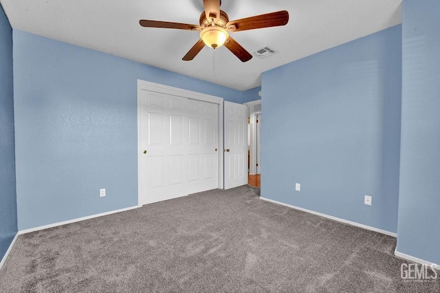 unfurnished bedroom featuring carpet flooring, a closet, baseboards, and visible vents