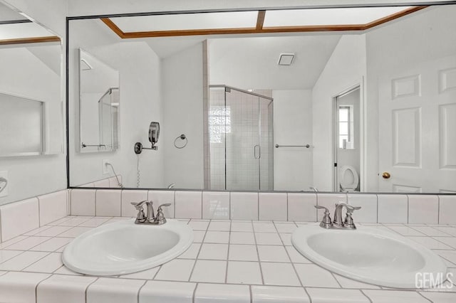 bathroom with vanity, a stall shower, and vaulted ceiling