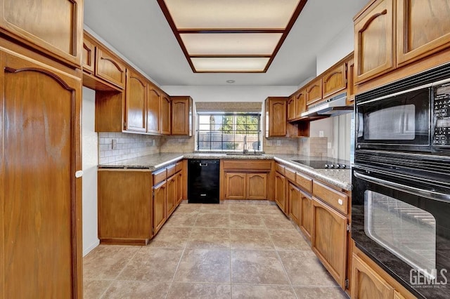 kitchen featuring brown cabinets, black appliances, under cabinet range hood, and a sink