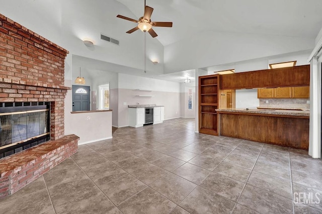 kitchen featuring tile patterned floors, wine cooler, a fireplace, tasteful backsplash, and ceiling fan