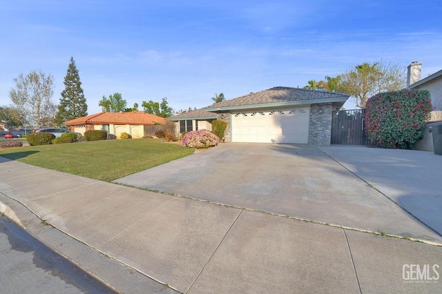 ranch-style home with driveway, fence, an attached garage, a front lawn, and a tiled roof