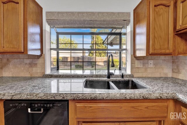 kitchen with black dishwasher, tasteful backsplash, a sink, and a healthy amount of sunlight