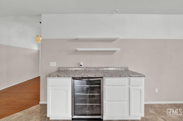 kitchen featuring white cabinets, light stone countertops, open shelves, beverage cooler, and light tile patterned floors