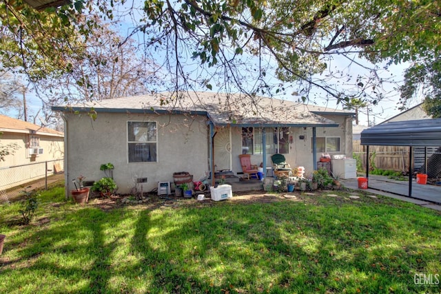 back of property featuring crawl space, stucco siding, a lawn, and fence